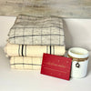 Various blankets in cream and grey with soft black stripe, red season greetings card and white hobnail jar candle with charm