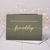 Grey cardstock with "Friendship" in gold leaf in the middle